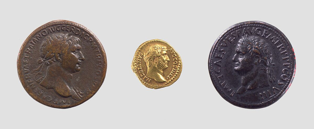 Trois monnaies romaines à portraits impériaux, avec un aureus d’Hadrien au centre.