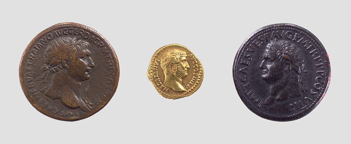Trois monnaies romaines à portraits impériaux, avec un aureus d’Hadrien au centre.