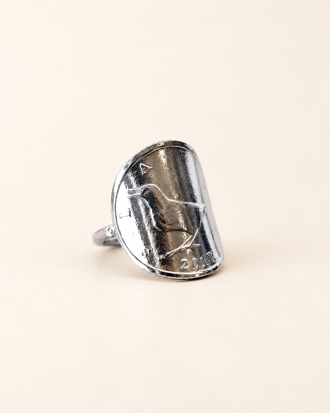 Bague de 1 kuna côté rossignol, vue de trois quarts sur fond clair.